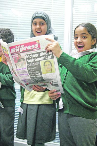 Pupils reading Asian Express Newspaper
