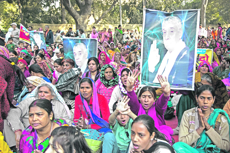 Supporters of controversial Indian guru Sant Rampal displaying his photographs, chant slogans praising him as they gather to show support at a protest venue