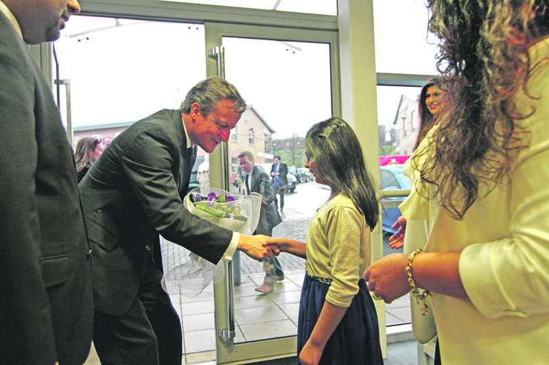 WARM WELCOME: Eight-year-old Shyla Hanif greets the Prime Minister at the Asian Express offices with a bouquet of flowers