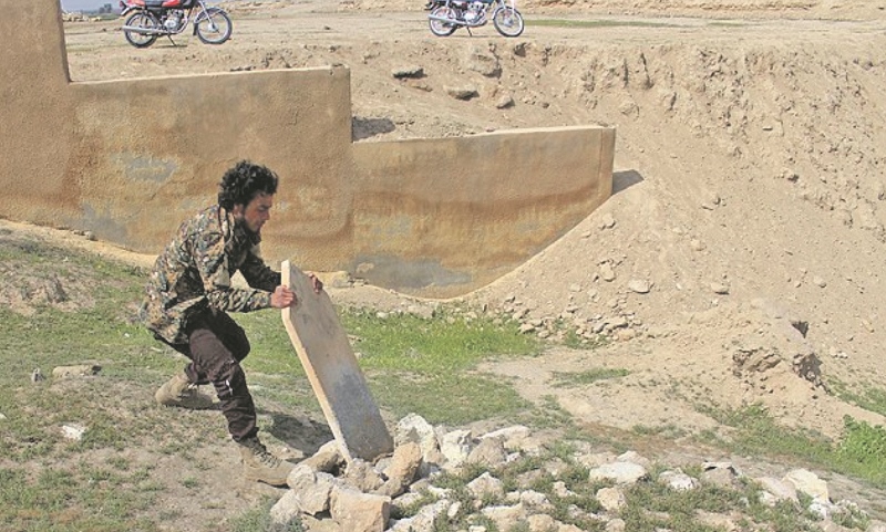 Turning on the dead: Having parked their motorcycles at the gates of the graveyard, several militants are seen inside pulling over tombstones.