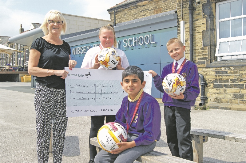 SHOOT: Children who raised the most sponsorship money from the penalty shootout were presented with a signed ball from Bradford City (clockwise from top left) Resource and event manager at Wibsey Primary, Christine Thwaite; Year 6 pupil, Maci Partridge; Year 4’s Kaiden Davey, and Ayaan Madassar from Year 3