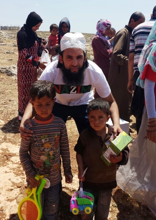 HELPING ALL AGES: Nazim is pictured here helping to distribute toys to Syrian children during an aid mission in June 2015