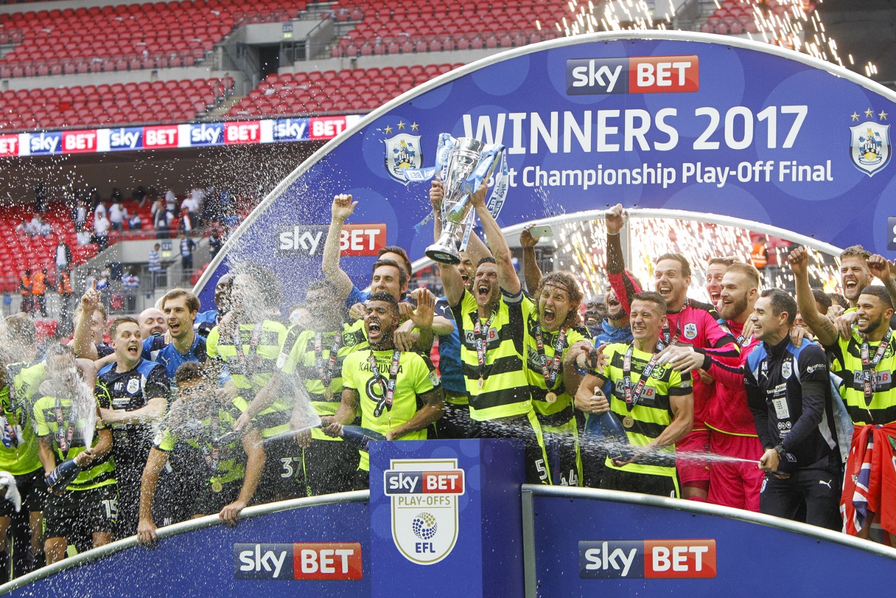 Ecstatic club captain Mark Hudson lifts play-off trophy aloft as Town celebrate being in the big time
