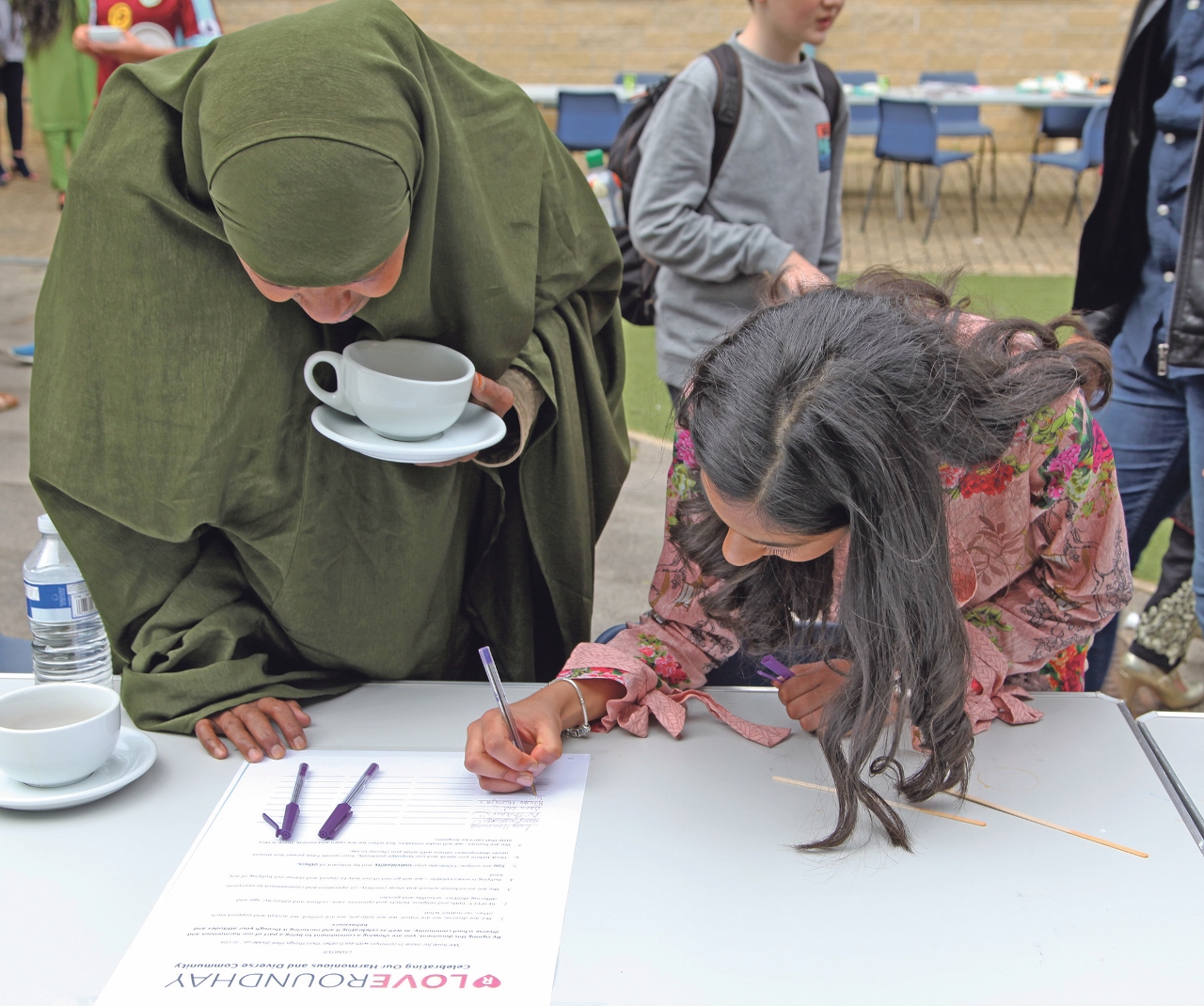 Nitasha Mustafa, 13, and parent Mrs Halima Ali signing the Love Roundhay Charter at the Gupshup event